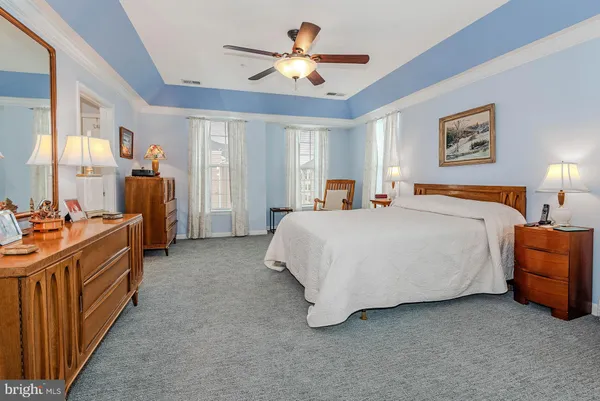 a spacious bedroom with a bed and ceiling chandelier