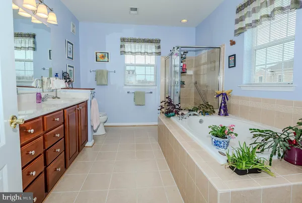 a bathroom with a granite countertop sink a toilet a mirror and shower