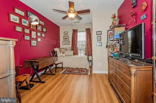 a living room with furniture a bookshelf and a window