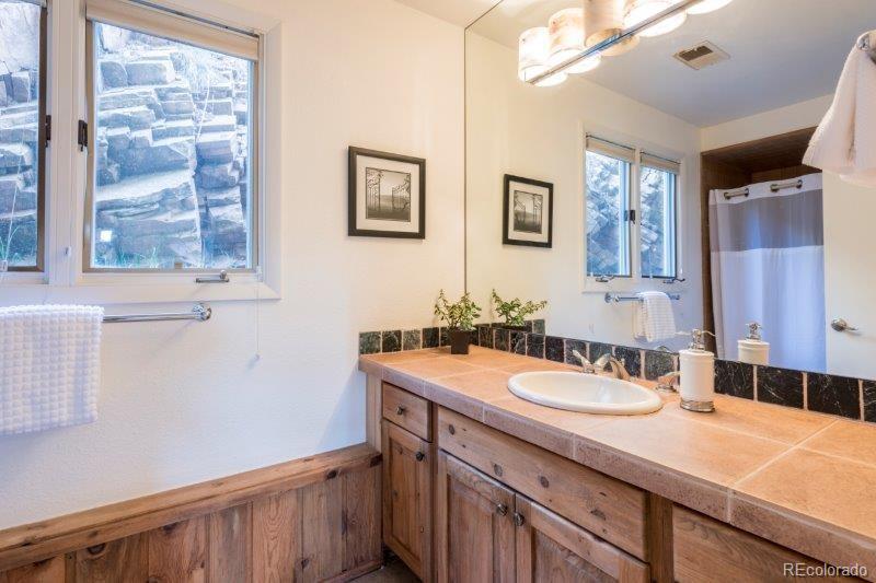 6513 Red Hill Road Boulder, CO 80302 - Photo 23 of 32 a bathroom with a sink double vanity and a shower
