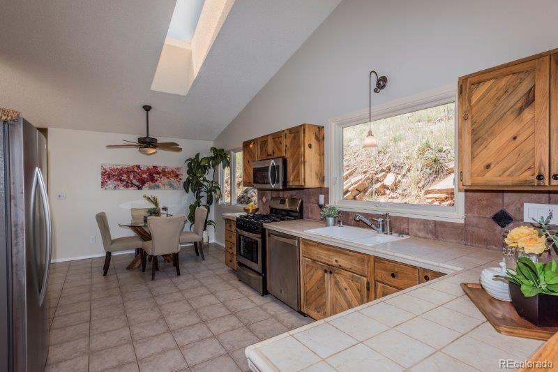 6513 Red Hill Road Boulder, CO 80302 - Photo 10 of 32 a view of a kitchen with kitchen island stainless steel appliances a dining table and chairs in it