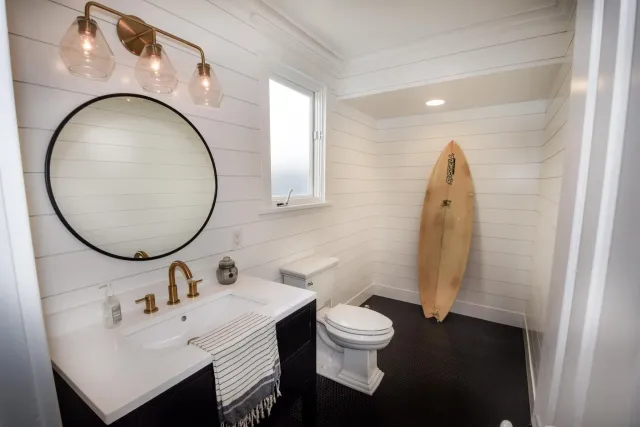 a bathroom with a sink a toilet and a mirror