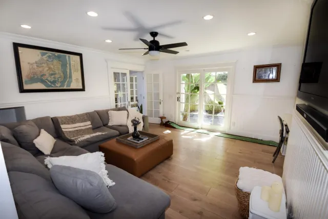 a living room with furniture a large window and a flat screen tv