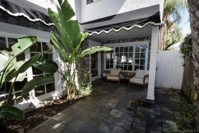 a view of a porch with chairs and potted plants