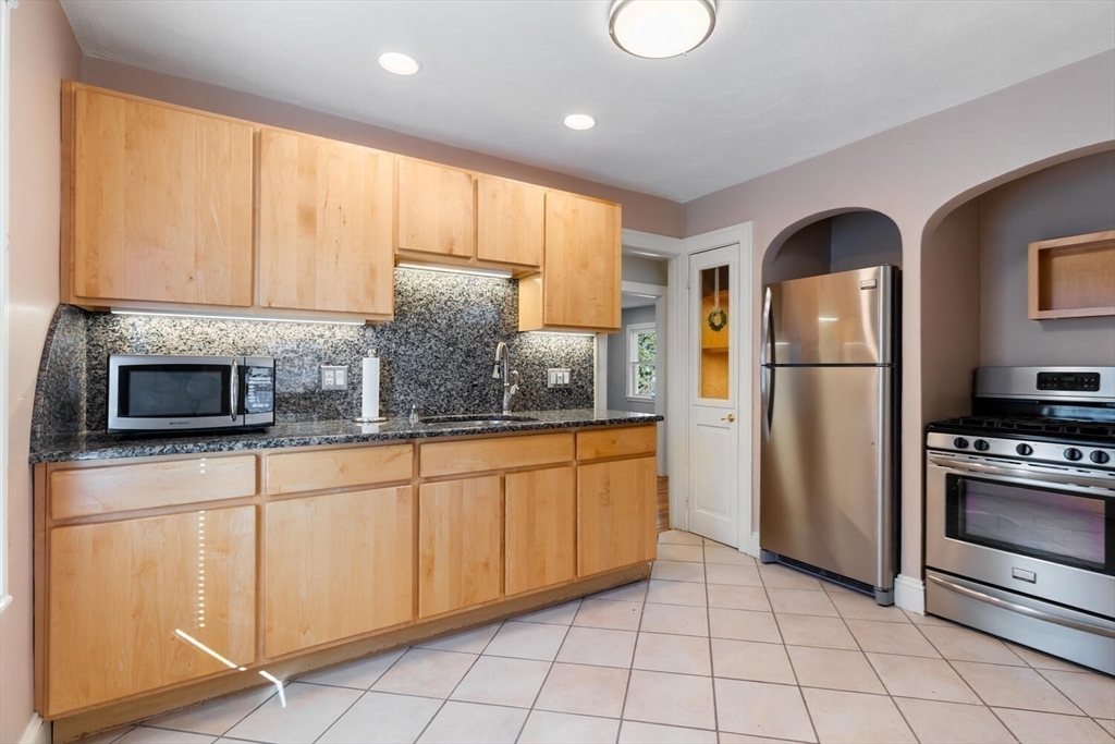 9 Wildwood Road Medford, MA 02155 - Photo 11 of 38 a kitchen with stainless steel appliances granite countertop a refrigerator a stove a sink and a microwave