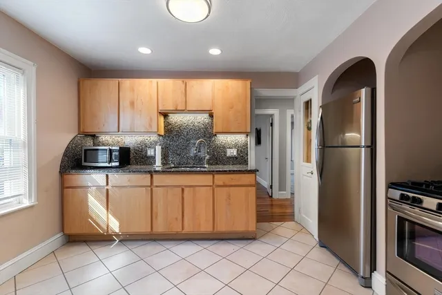 a kitchen with stainless steel appliances granite countertop a refrigerator and a sink