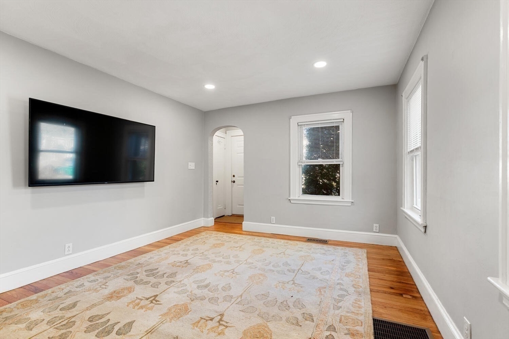 9 Wildwood Road Medford, MA 02155 - Photo 9 of 38 a view of an empty room with wooden floor and a window