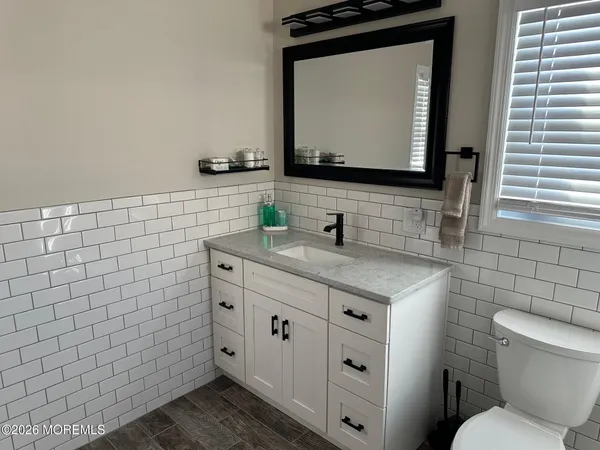 a bathroom with a granite countertop toilet sink and mirror