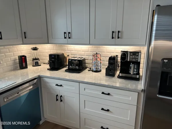 a kitchen with white cabinets and white appliances