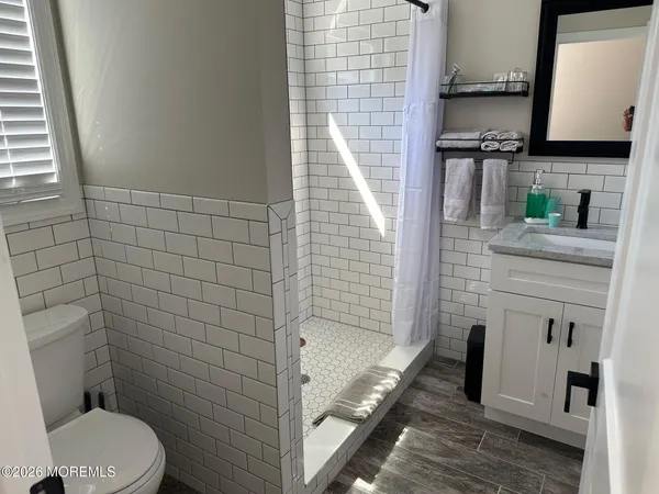 a bathroom with a granite countertop toilet a sink and mirror