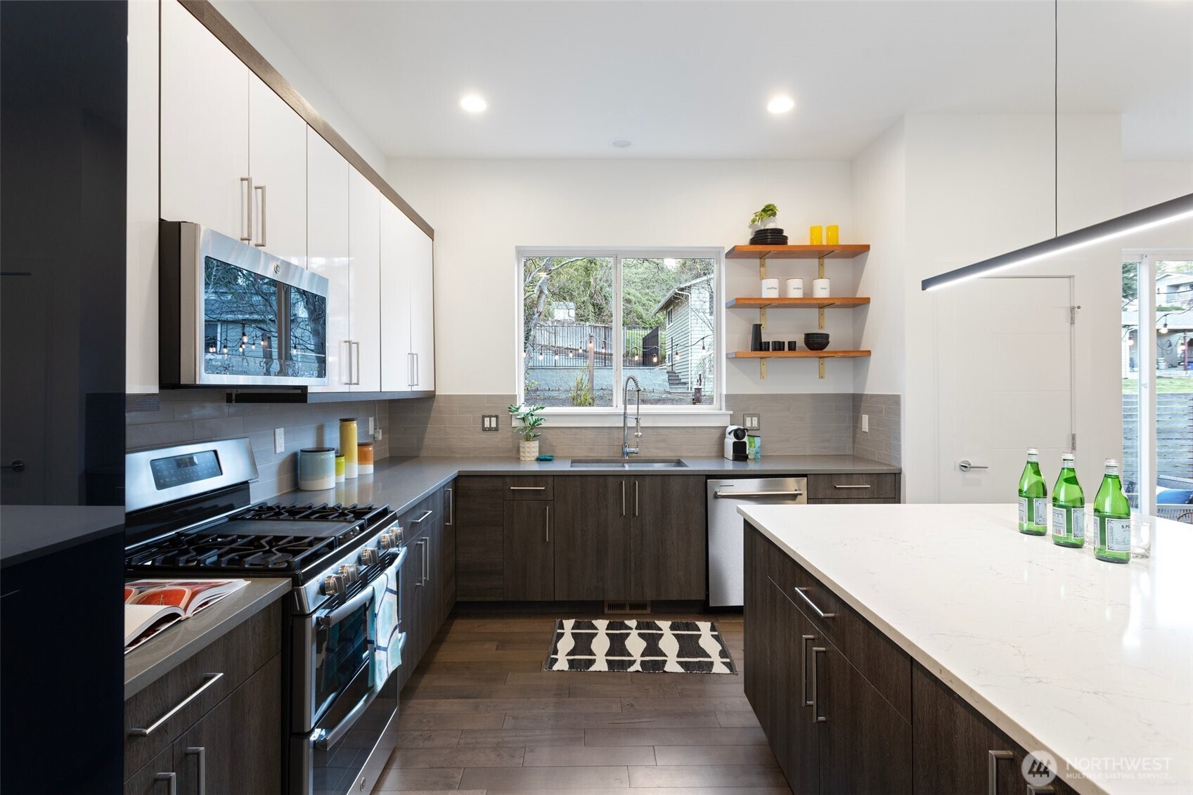 305 Stevens Avenue Southwest Renton, WA 98057 - Photo 13 of 40 a kitchen with stainless steel appliances a sink a stove a refrigerator cabinets and a window