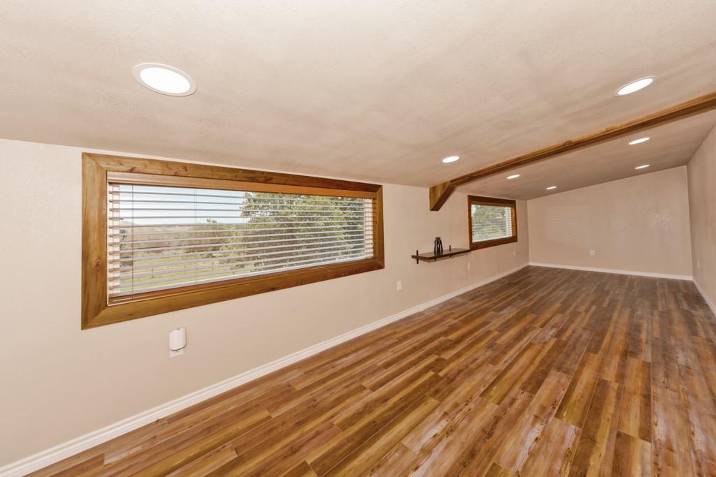 1216 Big Sandy Road Bellevue, TX 76228 - Photo 7 of 36 a view of an empty room with wooden floor and a window