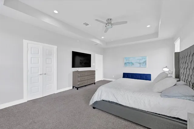a spacious bedroom with a bed and a flat screen tv
