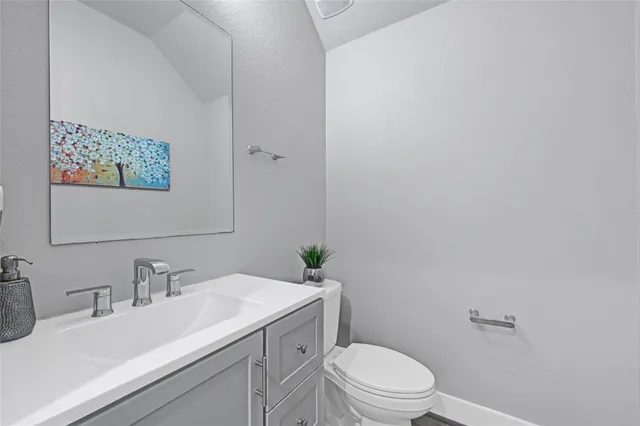 a bathroom with a sink mirror vanity and toilet