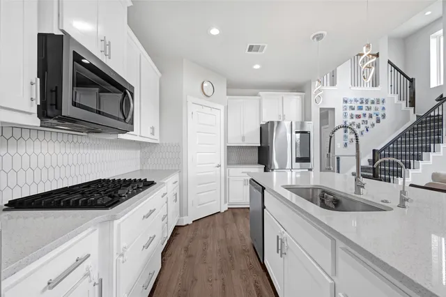 a kitchen with stainless steel appliances granite countertop a sink stove and refrigerator