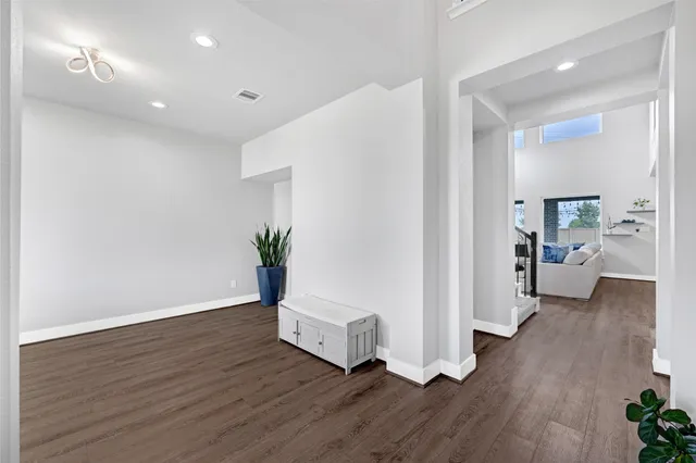 a view of a hallway with wooden floor and a living room