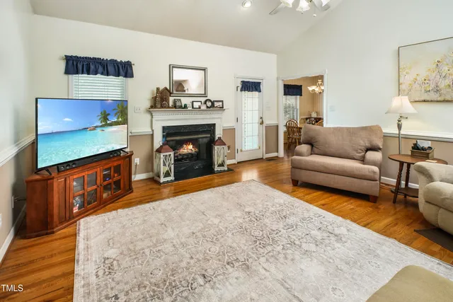 a living room with furniture a flat screen tv and a fireplace