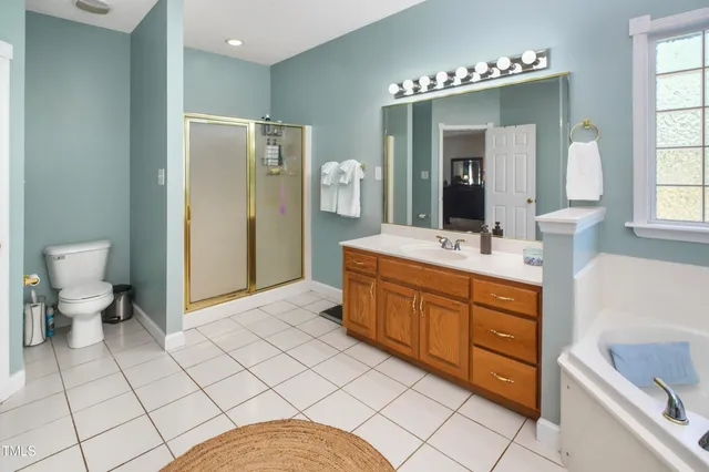 a spacious bathroom with a double vanity sink mirror and toilet