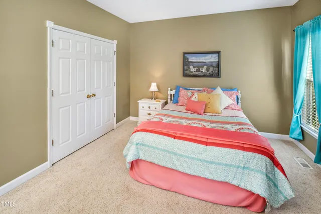 a bedroom with a bed and a painting on the wall