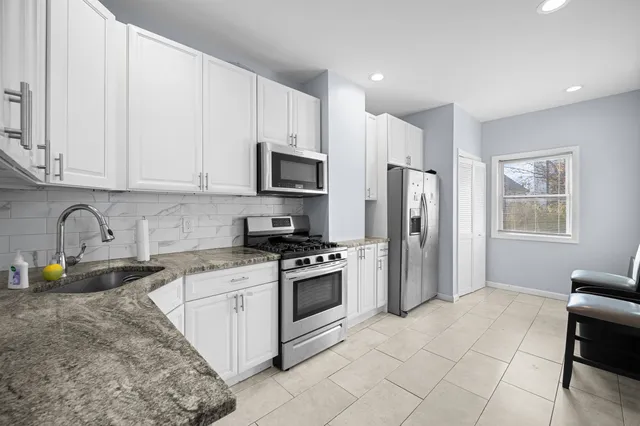 a kitchen with stainless steel appliances granite countertop a stove a sink dishwasher a refrigerator and a microwave