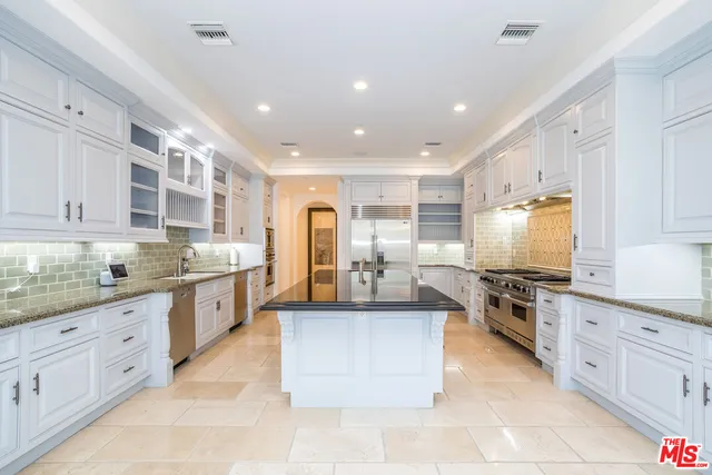 a large kitchen with stainless steel appliances lots of counter top space