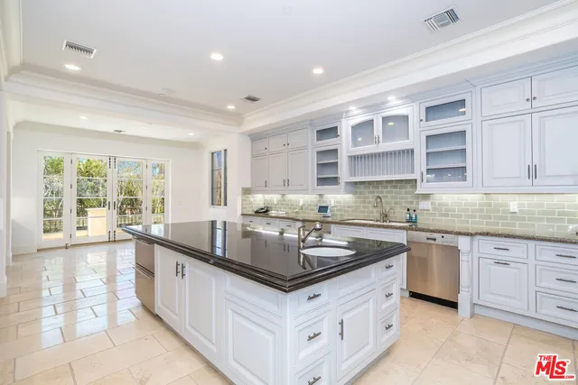a kitchen with granite countertop a sink and white cabinets