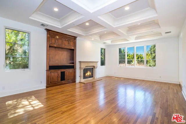 a view of a livingroom with wooden floor and a fireplace