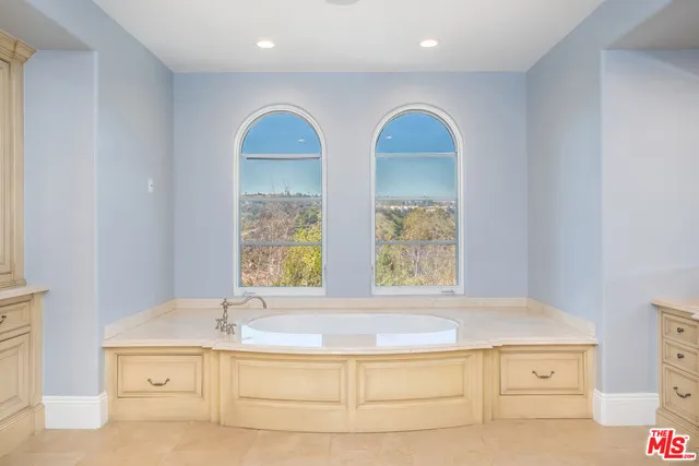 a bedroom with a bed and a flat tv screen on dresser