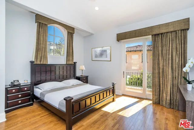 a spacious bedroom with a bed and glass window