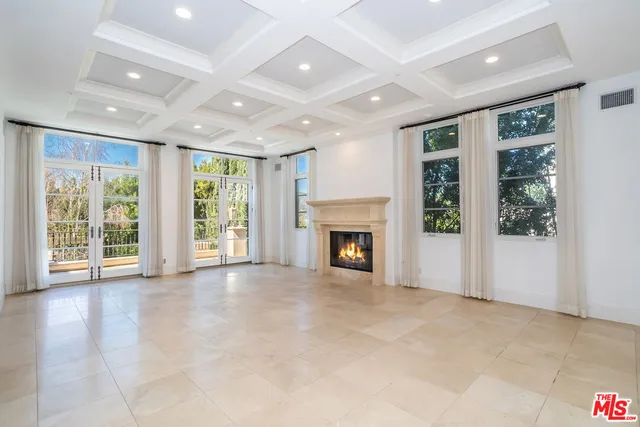 a view of an empty room with a fireplace and a window