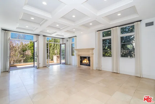 a view of an empty room with windows and a fireplace