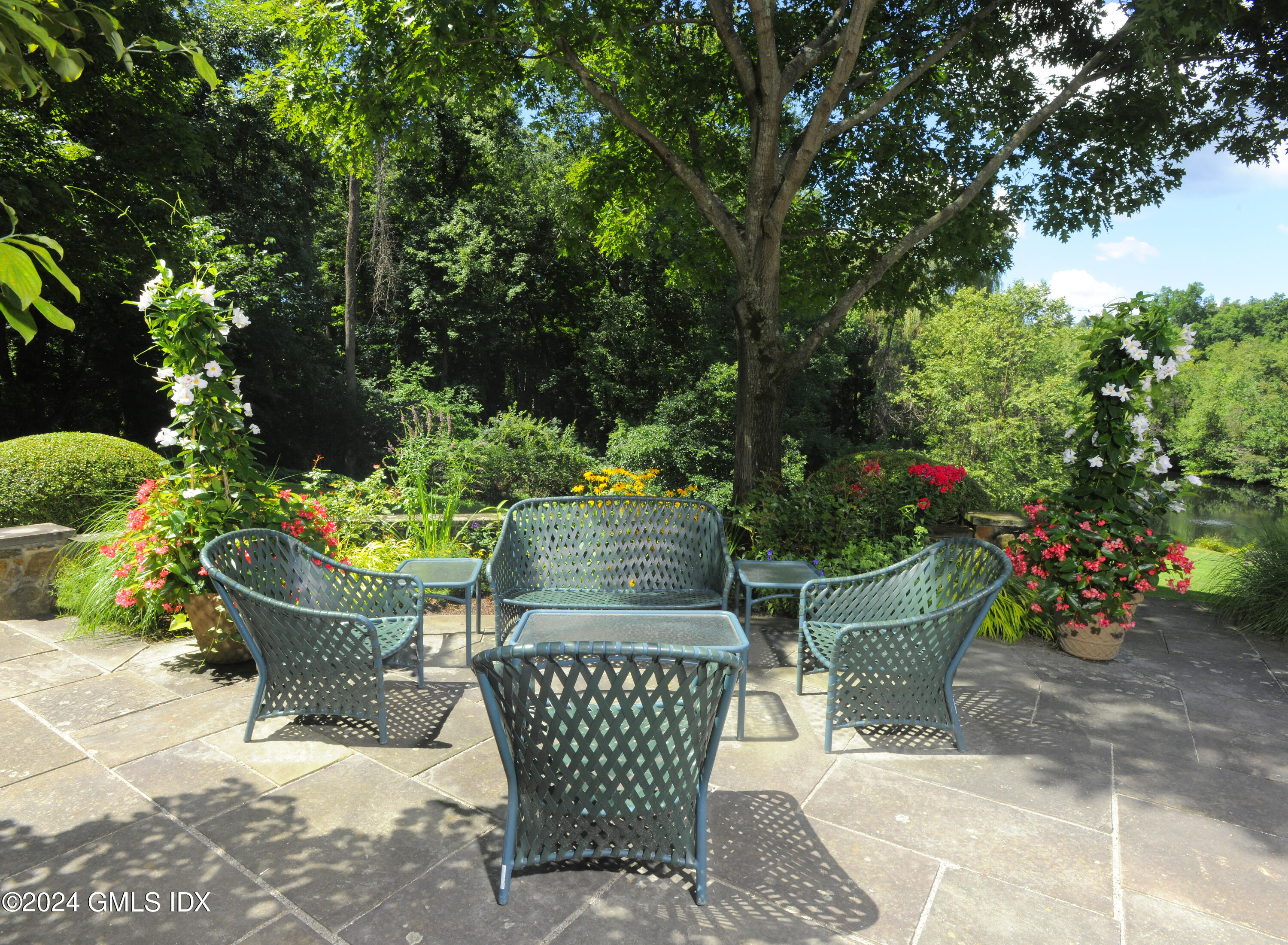 21 Dempsey Lane Greenwich, CT 06830 - Photo 26 of 32 a view of a chair and table in back yard of the house