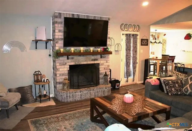 a living room with furniture a flat screen tv and a fireplace