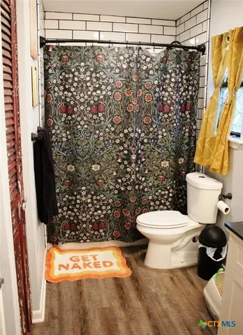 a bathroom with a toilet and a shower curtain