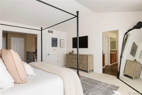 a bedroom with a bed flat screen tv and a couch