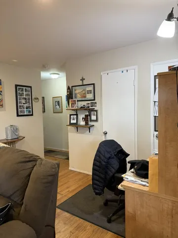 a living room with furniture and a refrigerator