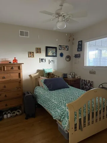 a bed sitting in a bedroom next to a window