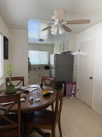 a view of a dining room with furniture and a chandelier fan