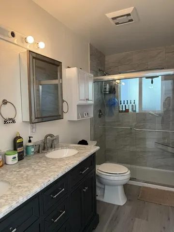 a bathroom with a double vanity sink toilet and shower