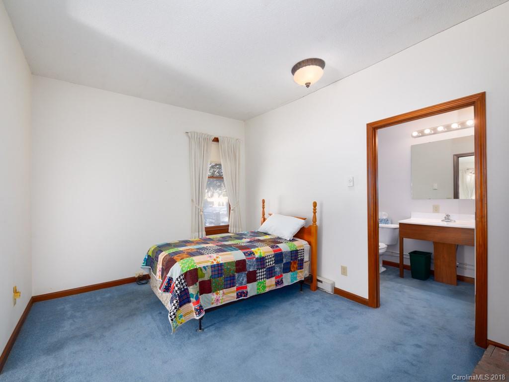 551 Bee Tree Road Swannanoa, NC 28778 - Photo 17 of 29 a bedroom with a bed and a table