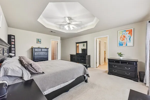 a spacious bedroom with a bed and dresser