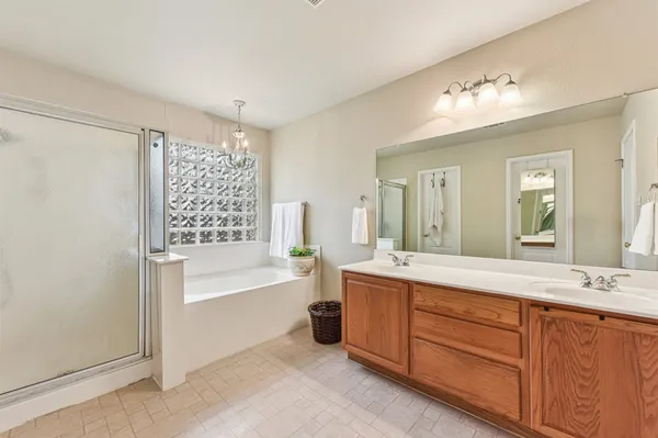 a spacious bathroom with a tub sink and mirror