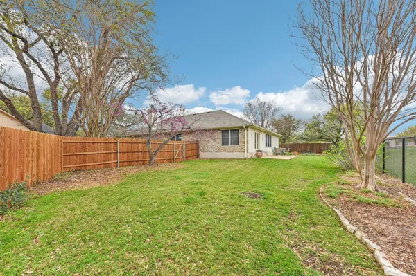 a view of a house with backyard and trees