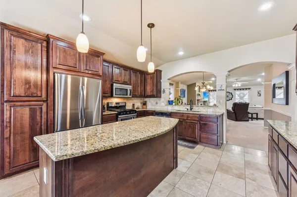 a kitchen with refrigerator a sink and chairs
