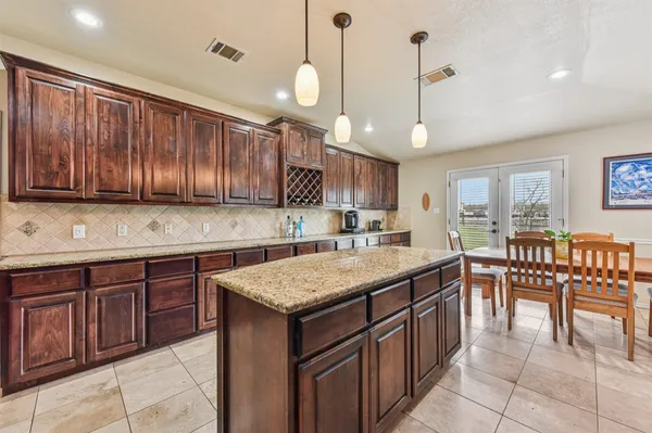 a kitchen with a wooden table chairs sink and cabinets