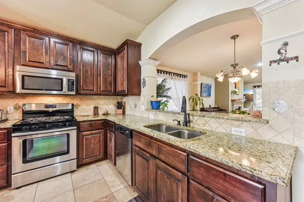 a kitchen with stainless steel appliances granite countertop a sink stove and microwave