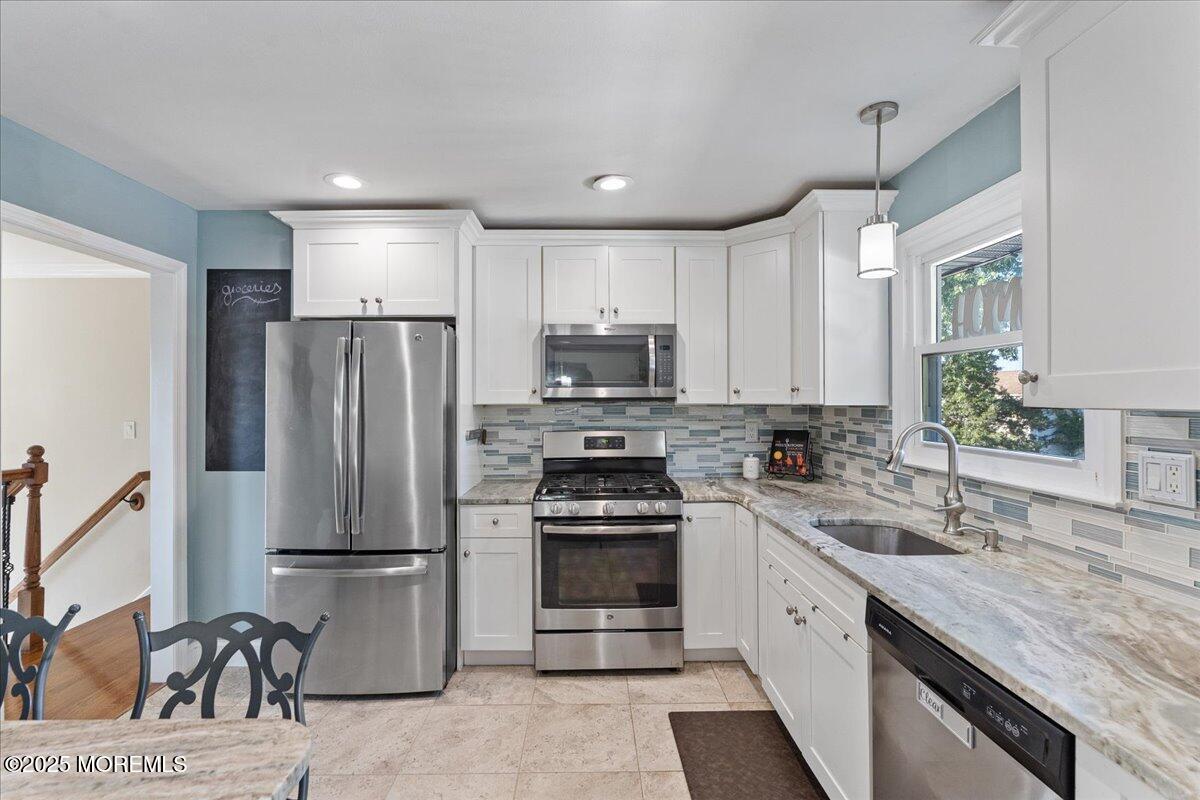 165 Port Road Brick, NJ 08723 - Photo 12 of 48 a kitchen with refrigerator a sink and chairs