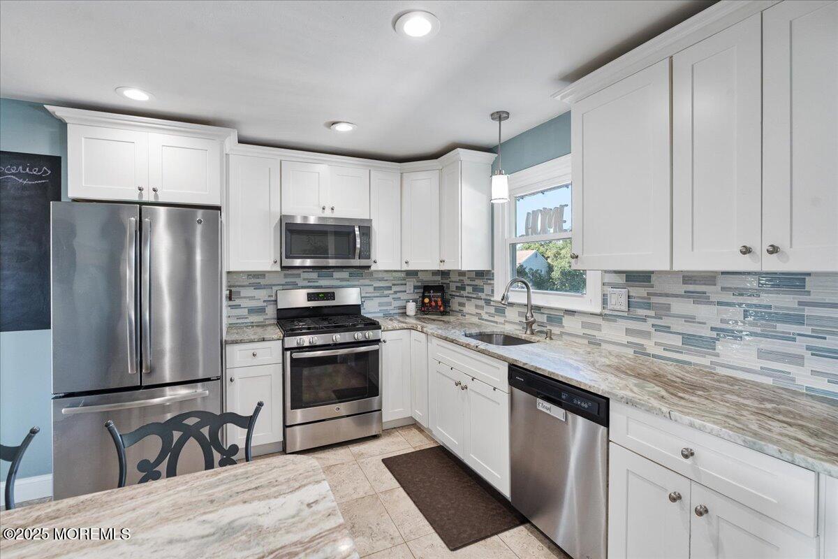 165 Port Road Brick, NJ 08723 - Photo 13 of 48 a kitchen with stainless steel appliances granite countertop a stove a sink and a refrigerator