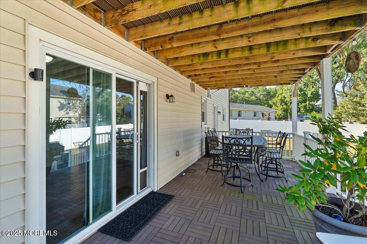 165 Port Road Brick, NJ 08723 - Photo 34 of 48 a patio with table and chairs and potted plants with wooden floor