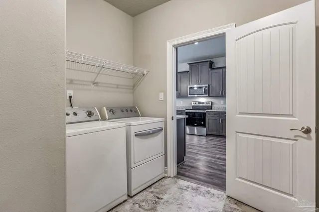 an empty room with chandelier fan and windows